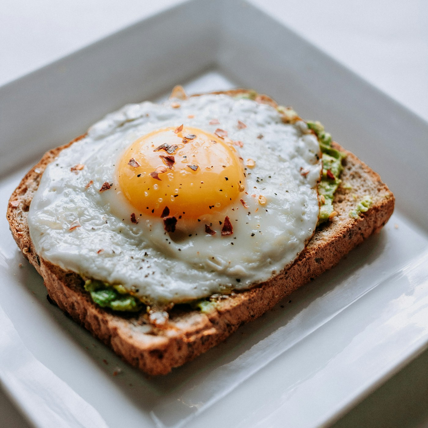 Kaya toast on a plate with kopi in a traditional glass